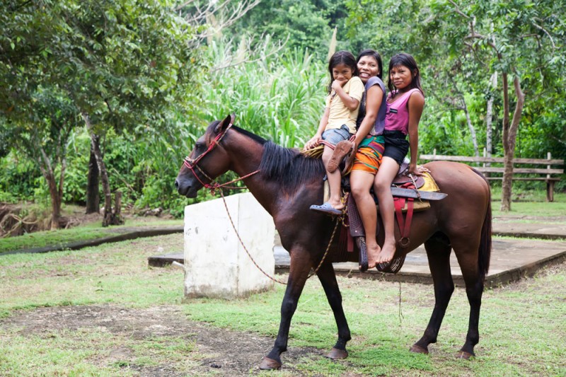 Indianen kinderen rijden paard. Embera Panama, Darien