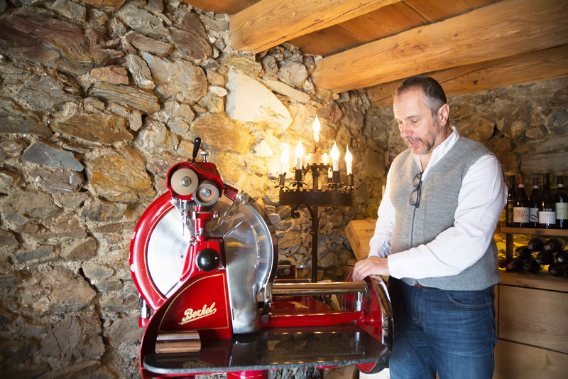 Stefano achter zijn vleessnijmachine - San Lorenzo Mountain lodge in Sud Tirol, Italie