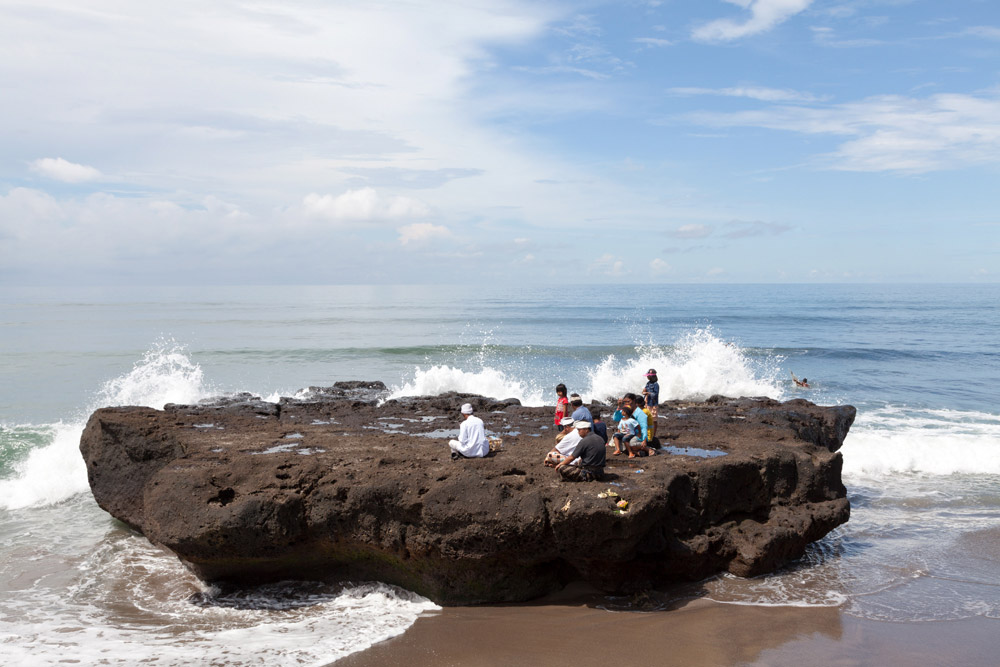 Bidden op een rots in zee, in het zuiden van Bali