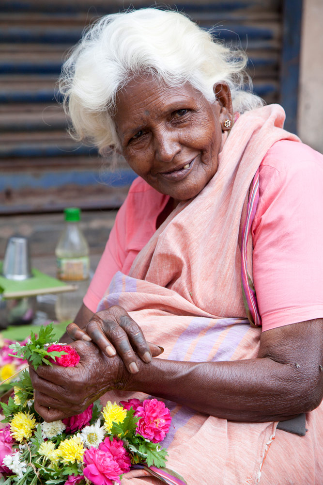 Vrouwen maken bloemenkransen voor tempelbezoekers, Tamil Nadu, India