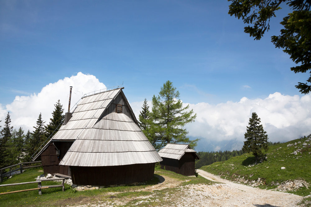 Herdershutten met houten dakpannen op het plateau Velika planina , Wandelen op het plateau Velika planina nabij de stad Kamnik in Slovenie