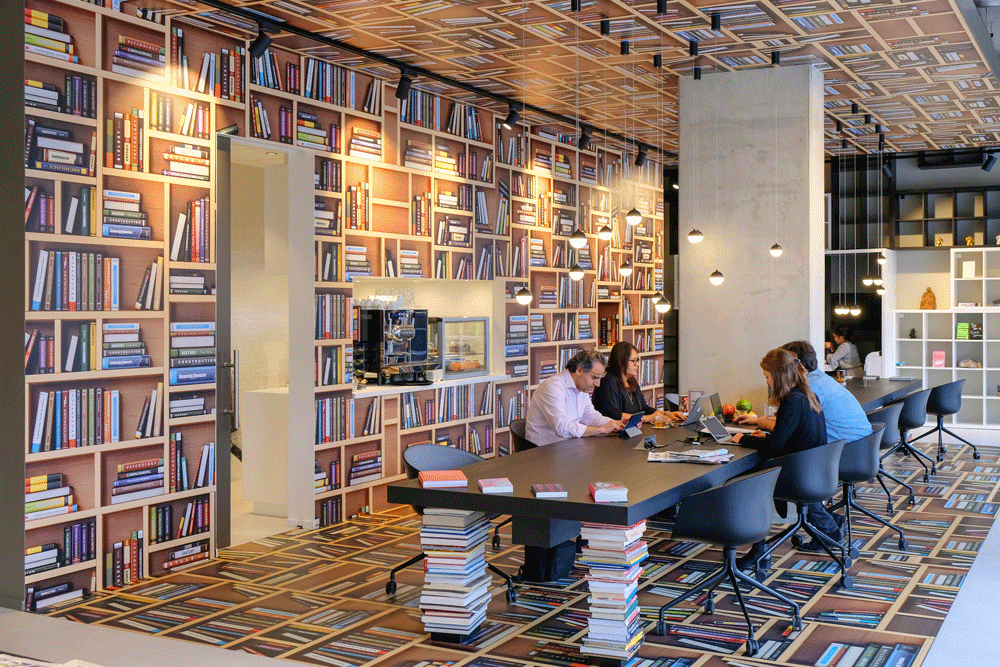 Er zijn flex werkplekken aan lange tafels. - My Flex werkplek en boekwinkel, Bookstore en My Flex Space in Amsterdam.