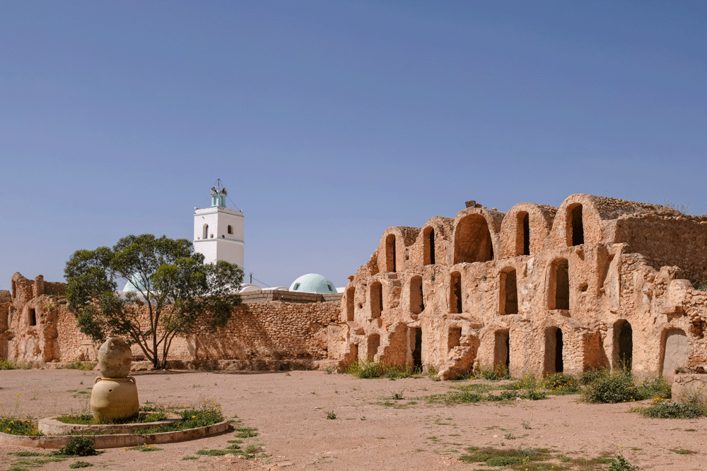 De ksar met ghorfas en in de achtergrond een moskee in Metameur - Vakantie Djerba, Tunesie, rondreis, strandvakantie