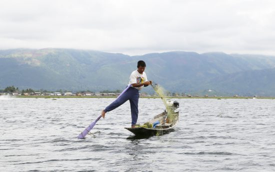 De vissers van het Inlemeer roeien met hun benen.. Inlemeer, Inle Lake, Myanmar, Birma