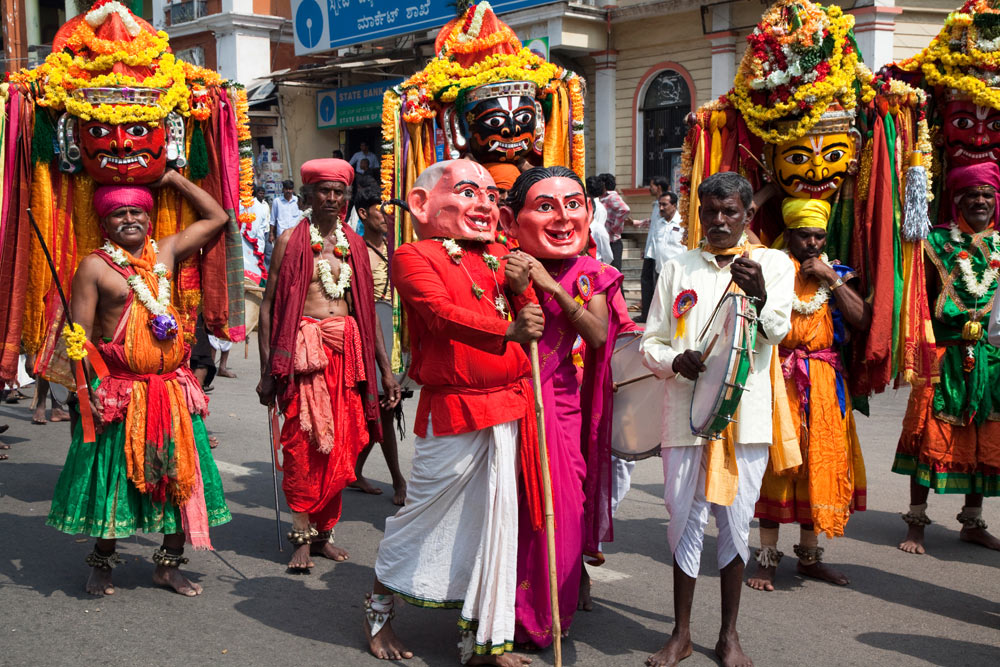 Veel mensen dragen een hoofd van papier mache mee. rondreis Zuid-India, Kerala. Autorondreis