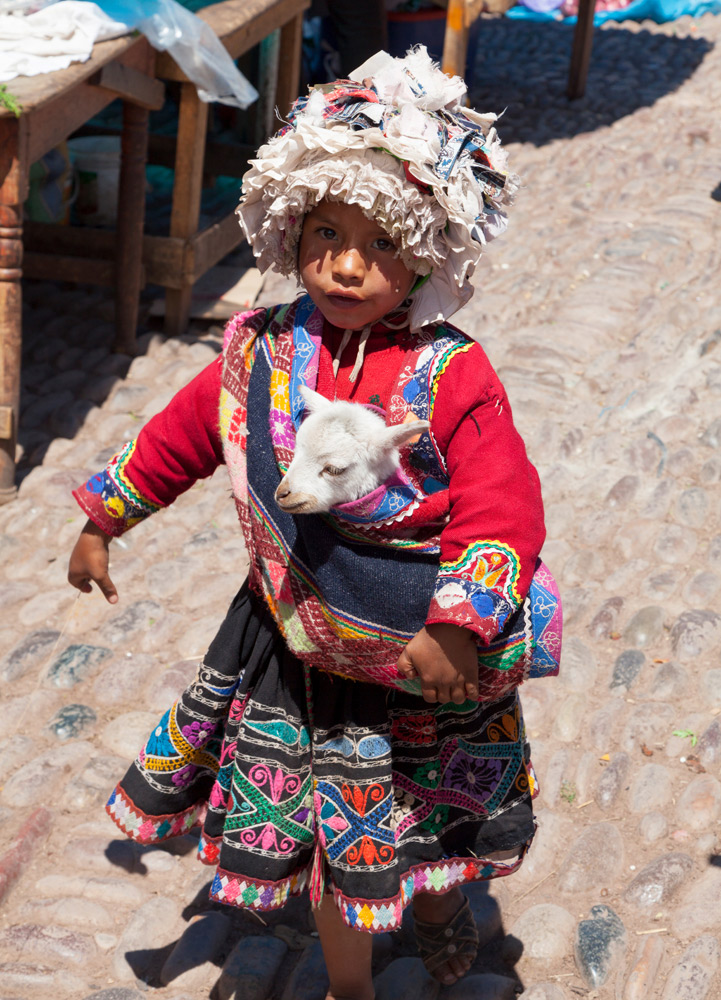Kindje met geitje op de markt van Pisac, Peru, Peru, rondreis, rondreizen, vakantie, Lima, cusco, heilige vallei, hotels, tips, bezienswaardigheden, highlights, hotspots,