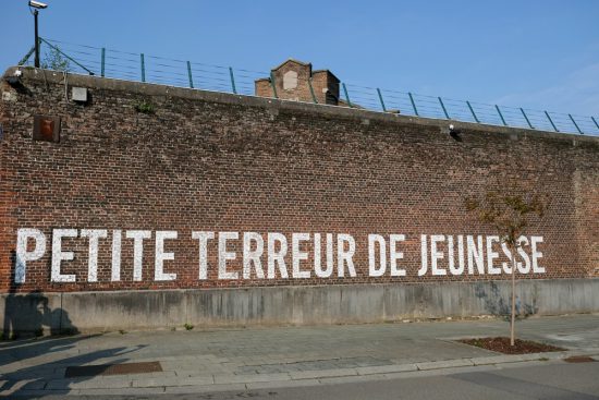 Poezie op muren van de gevangenis in MonsStedentrip Mons, Bergen in Wallonie, Belgie. Met de hotpost en bezienswaardigheden en tips voor leuke winkels en goede restaurants