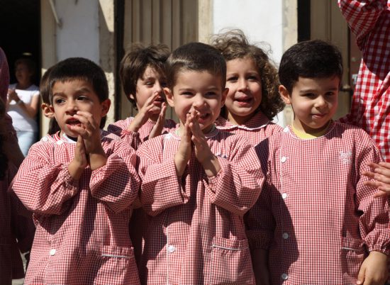 Enthousiaste kinderen kijken naar de optocht in Tomar. Festa dos Tabuleiros, Tomar, Portugal