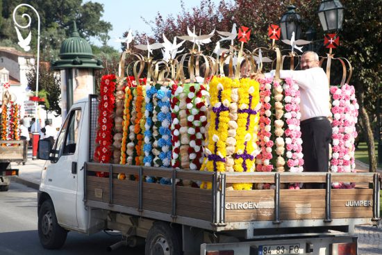De tabuleiros mogen nog even op een vrachtwagen mee naar het beginpunt. Festa dos Tabuleiros, Tomar, Portugal