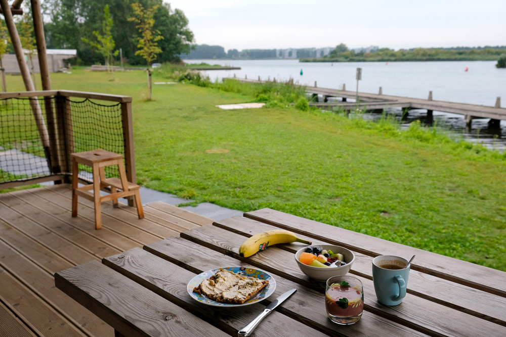 Ontbijten op de veranda van mijn safaritent op Camping Waterhout. Kamperen in Almere, camping Waterhout. Noorderplassen, fietsen, fietsvakantie, fietsroutes, Stedentrip Almere, staycation, hotspots